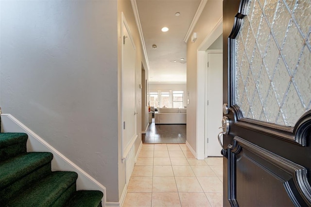 foyer featuring stairs, light tile patterned floors, baseboards, and ornamental molding