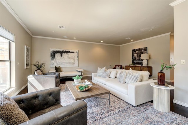 living room with baseboards, wood finished floors, visible vents, and ornamental molding