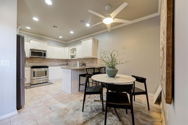 kitchen featuring decorative backsplash, ornamental molding, visible vents, and stainless steel appliances