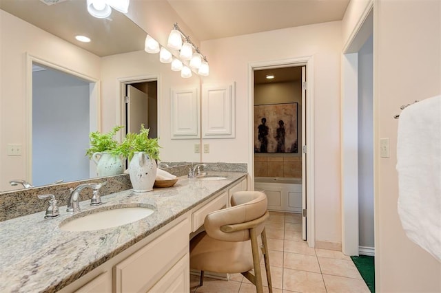 bathroom with a sink, a bathing tub, double vanity, and tile patterned flooring