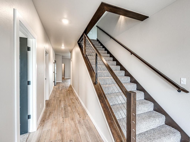 stairway with baseboards and wood finished floors