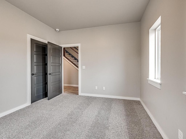 unfurnished bedroom with carpet and baseboards