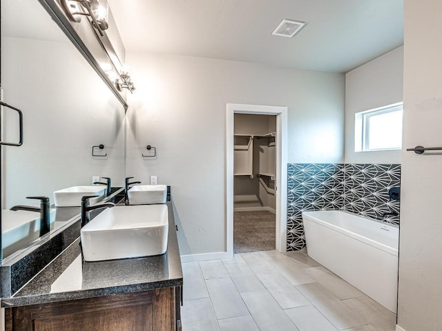 full bath with a sink, visible vents, and a freestanding bath