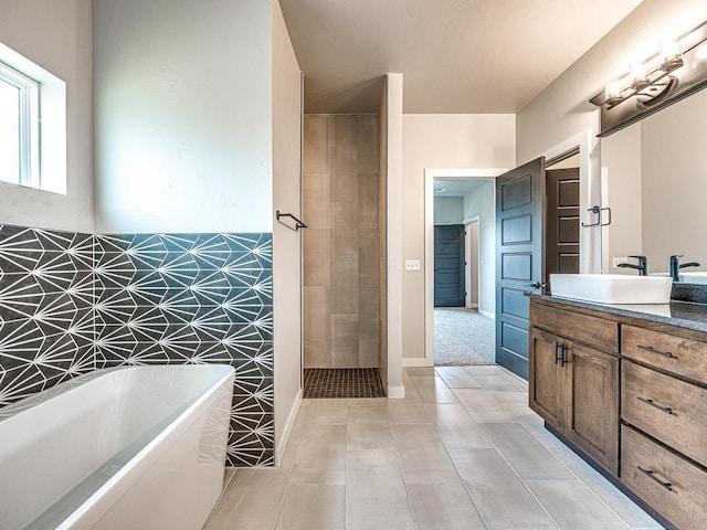 bathroom featuring a freestanding tub, vanity, and tile patterned flooring