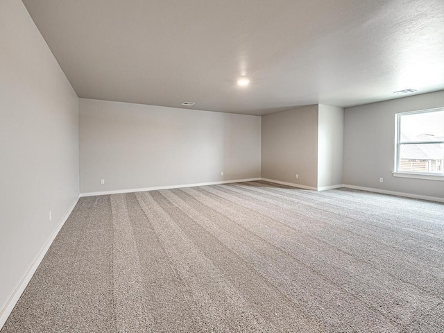 empty room with visible vents, baseboards, and carpet