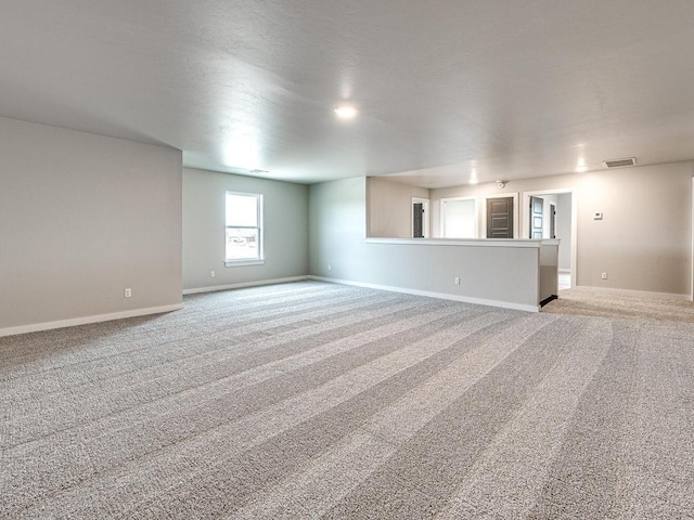 empty room with visible vents, baseboards, and carpet floors