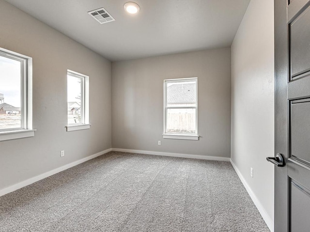 empty room with visible vents, baseboards, carpet, and a healthy amount of sunlight