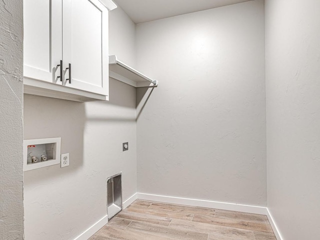 laundry area featuring hookup for a washing machine, baseboards, cabinet space, electric dryer hookup, and light wood-style floors