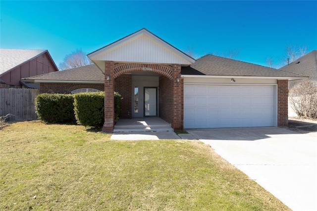 view of front of property with a front lawn, fence, concrete driveway, an attached garage, and brick siding