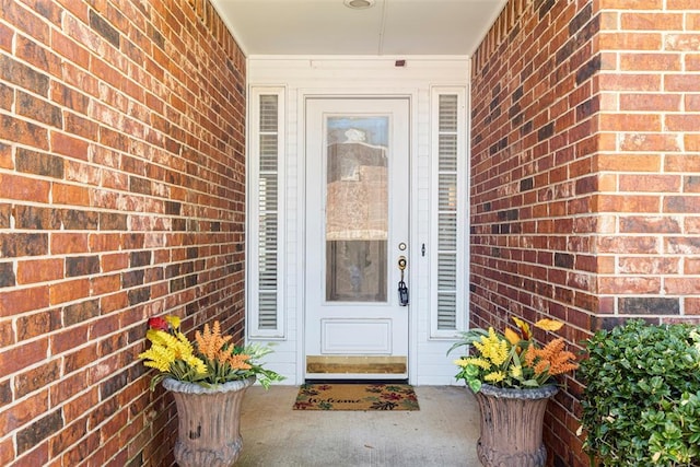 doorway to property featuring brick siding