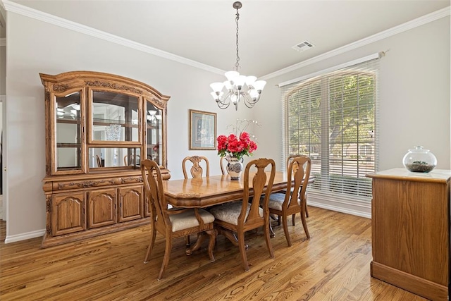 dining space with a notable chandelier, light wood-style floors, visible vents, and ornamental molding