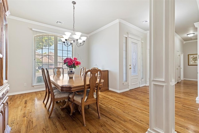 dining area with baseboards, visible vents, light wood finished floors, an inviting chandelier, and crown molding