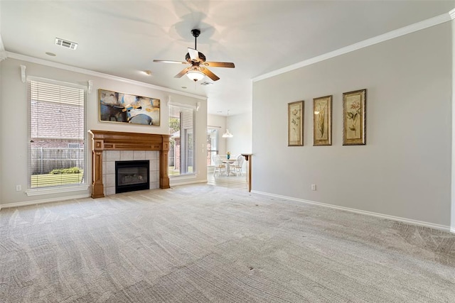 unfurnished living room with a ceiling fan, baseboards, visible vents, ornamental molding, and light carpet