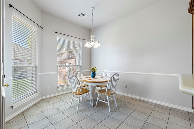 dining space with light tile patterned floors, visible vents, an inviting chandelier, and a healthy amount of sunlight