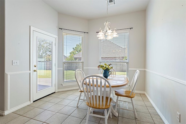 dining space featuring an inviting chandelier, light tile patterned floors, baseboards, and visible vents