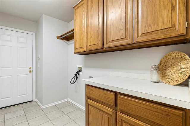 washroom with baseboards, light tile patterned floors, hookup for a washing machine, cabinet space, and electric dryer hookup