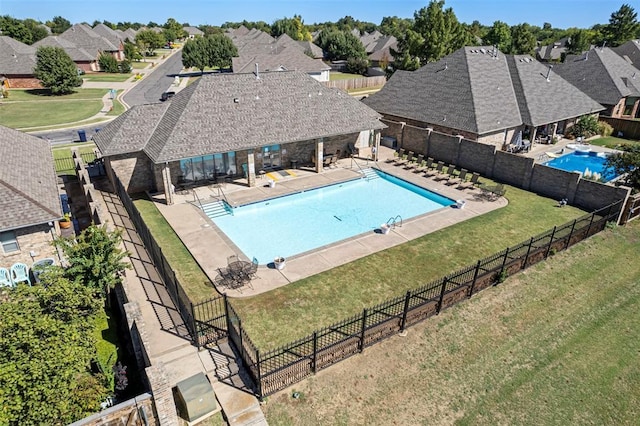 community pool with a patio area, a residential view, and fence