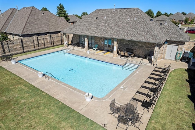 view of swimming pool with a fenced in pool, fence, a lawn, and a patio area