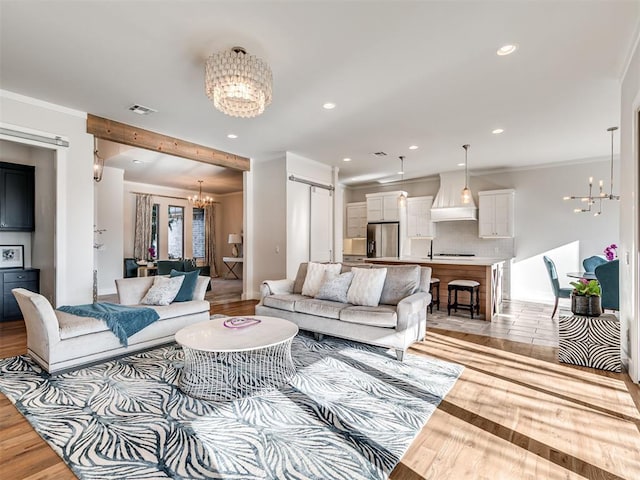 living room with visible vents, a notable chandelier, ornamental molding, recessed lighting, and light wood-style floors