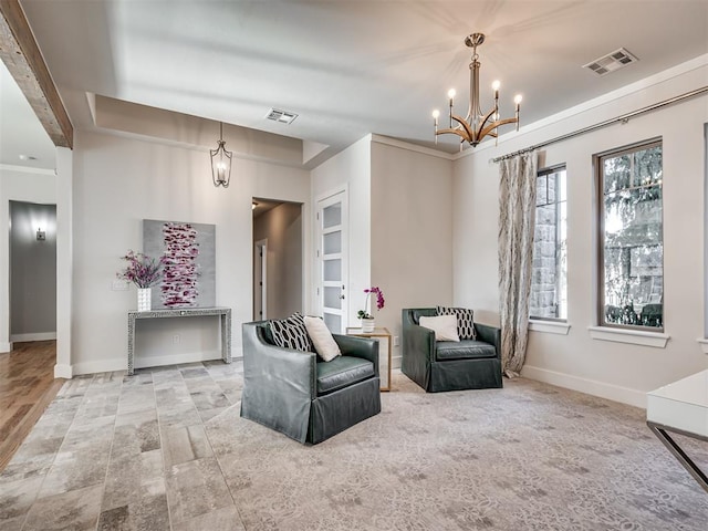 living area with visible vents, baseboards, a notable chandelier, and crown molding