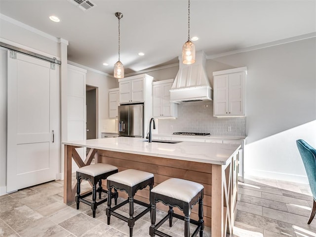 kitchen with ornamental molding, a sink, backsplash, stainless steel fridge, and custom exhaust hood