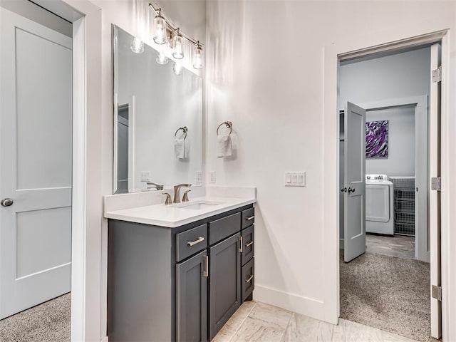 bathroom with baseboards, washer / dryer, and vanity