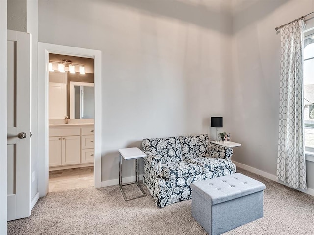 living area featuring baseboards and light carpet