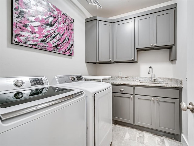 laundry room featuring washer and dryer, cabinet space, and a sink