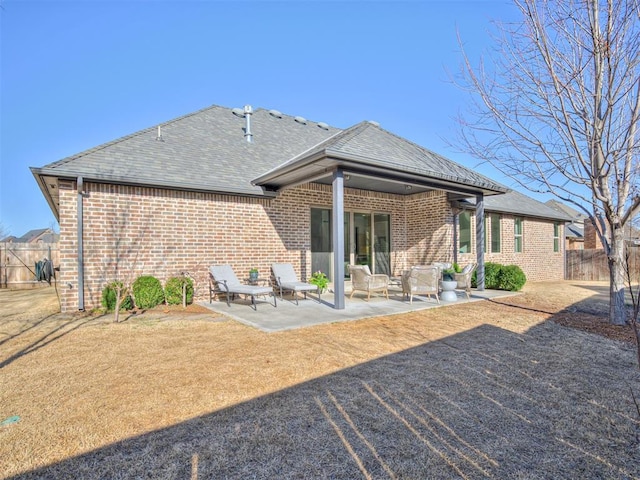 back of house featuring a patio area, fence, brick siding, and a shingled roof