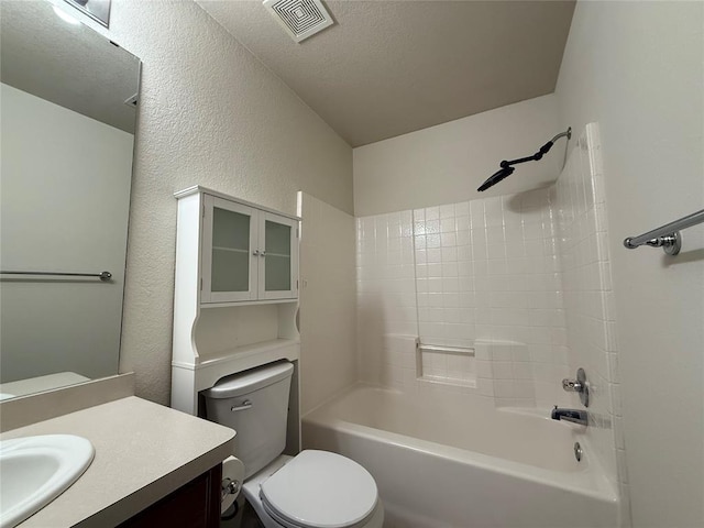 full bathroom with visible vents, toilet,  shower combination, vanity, and a textured wall