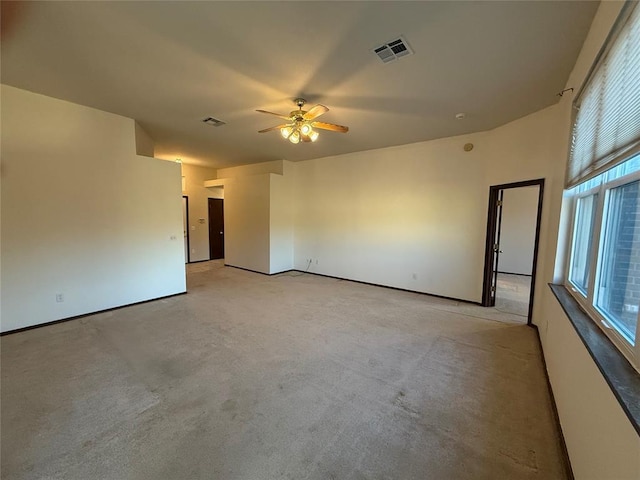 unfurnished room featuring a ceiling fan, visible vents, and light carpet