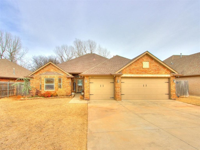 view of front of property with fence, driveway, roof with shingles, a garage, and brick siding