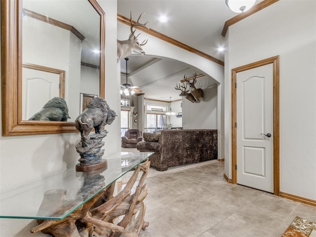 dining area with baseboards, arched walkways, ceiling fan, and crown molding