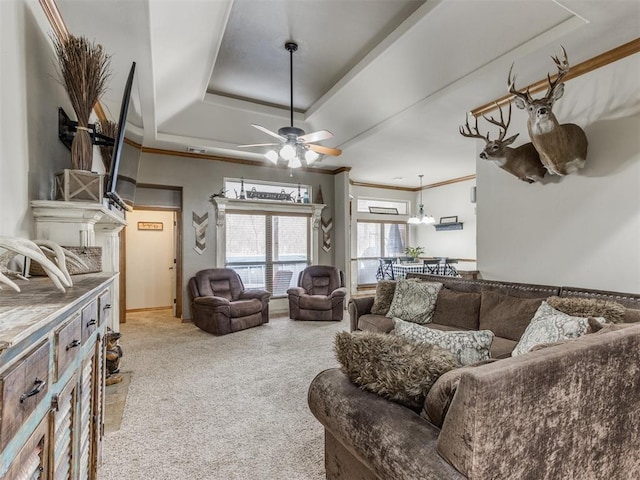 living room with a raised ceiling, light colored carpet, ornamental molding, and a ceiling fan