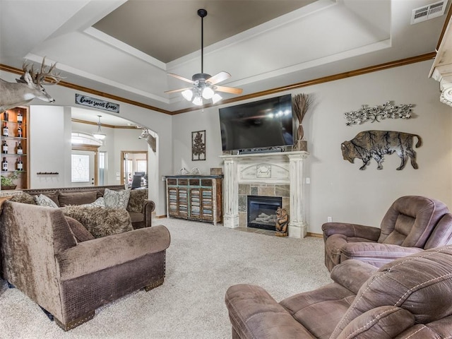 living area with visible vents, a raised ceiling, carpet floors, and a tile fireplace