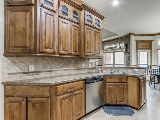 kitchen with backsplash, dishwasher, light stone counters, a peninsula, and a sink