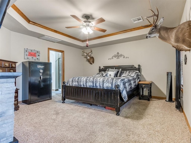 carpeted bedroom with ceiling fan, visible vents, a raised ceiling, and ornamental molding