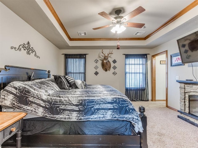 carpeted bedroom featuring visible vents, crown molding, and a tray ceiling