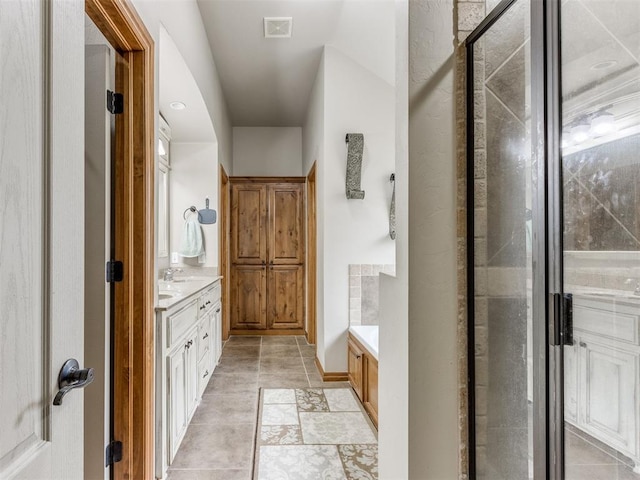 bathroom featuring visible vents, an enclosed shower, and vanity