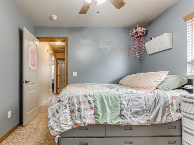 bedroom featuring light colored carpet, a ceiling fan, and baseboards