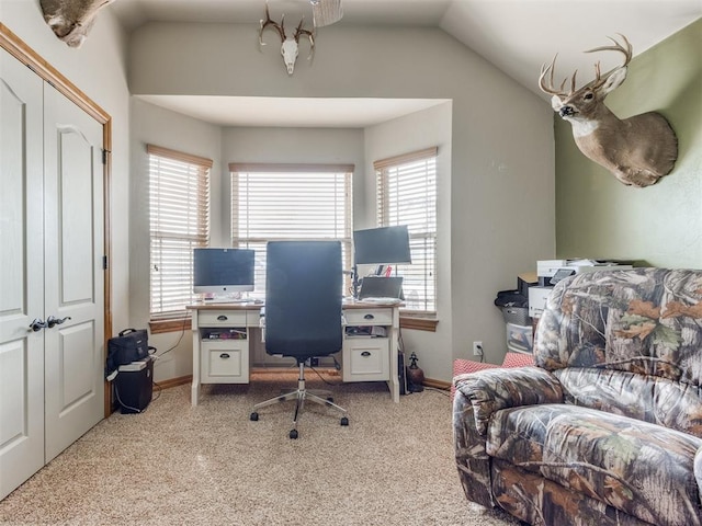 office space featuring light carpet, baseboards, and lofted ceiling