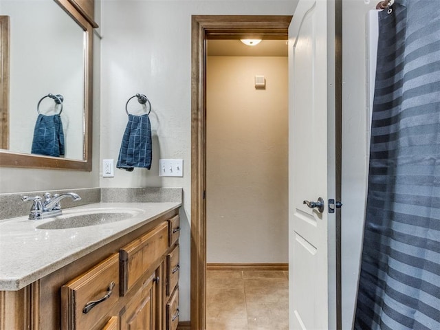 bathroom with tile patterned flooring, vanity, and baseboards