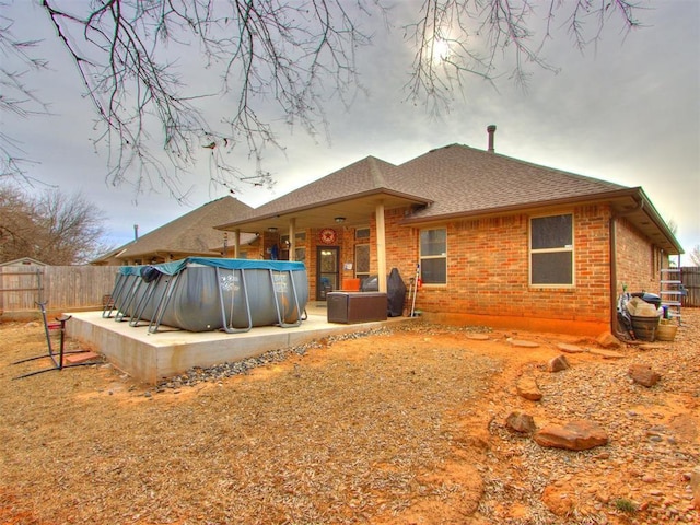 back of property featuring a patio area, fence, a fenced in pool, and brick siding