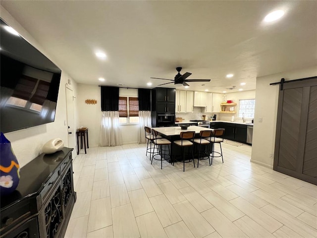 dining room with recessed lighting, a barn door, and ceiling fan