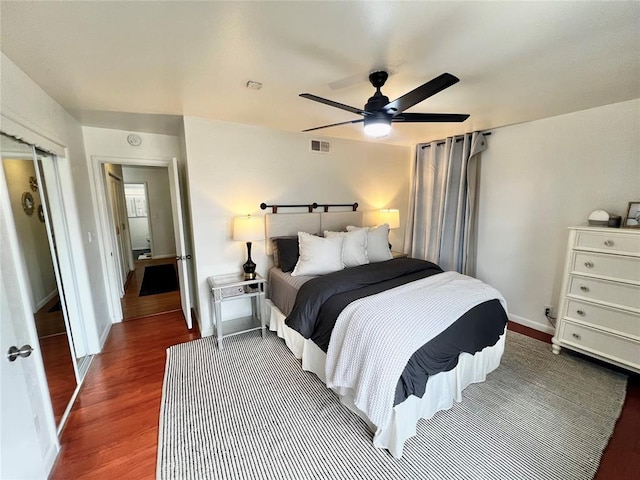 bedroom featuring baseboards, wood finished floors, visible vents, and ceiling fan