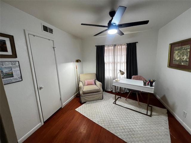 living area featuring visible vents, baseboards, a ceiling fan, and wood finished floors