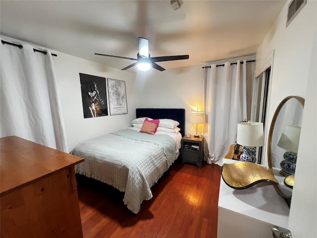 bedroom with dark wood-type flooring, visible vents, and ceiling fan