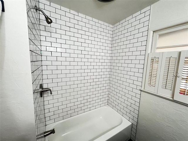 full bath featuring shower / tub combination and a textured wall