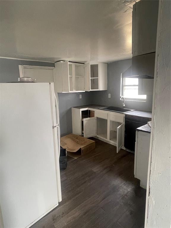 kitchen featuring a sink, dark wood-type flooring, freestanding refrigerator, white cabinets, and open shelves