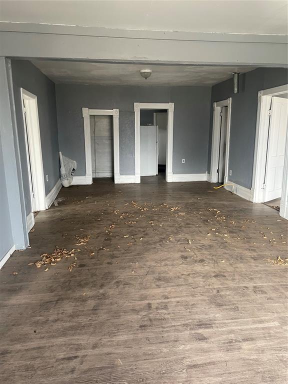 interior space featuring two closets, wood finished floors, baseboards, and freestanding refrigerator